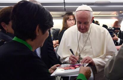 El Pontífice firma autógrafos a periodistas durante el vuelo desde Italia a Myanmar antes de su visita oficial al país asiático. 