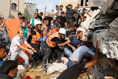 Miembros de los servicios de emergencia y vecinos buscaban víctimas bajo los escombros tras un bombardeo israelí sobre Jan Yunis, en la franja de Gaza, este domingo.