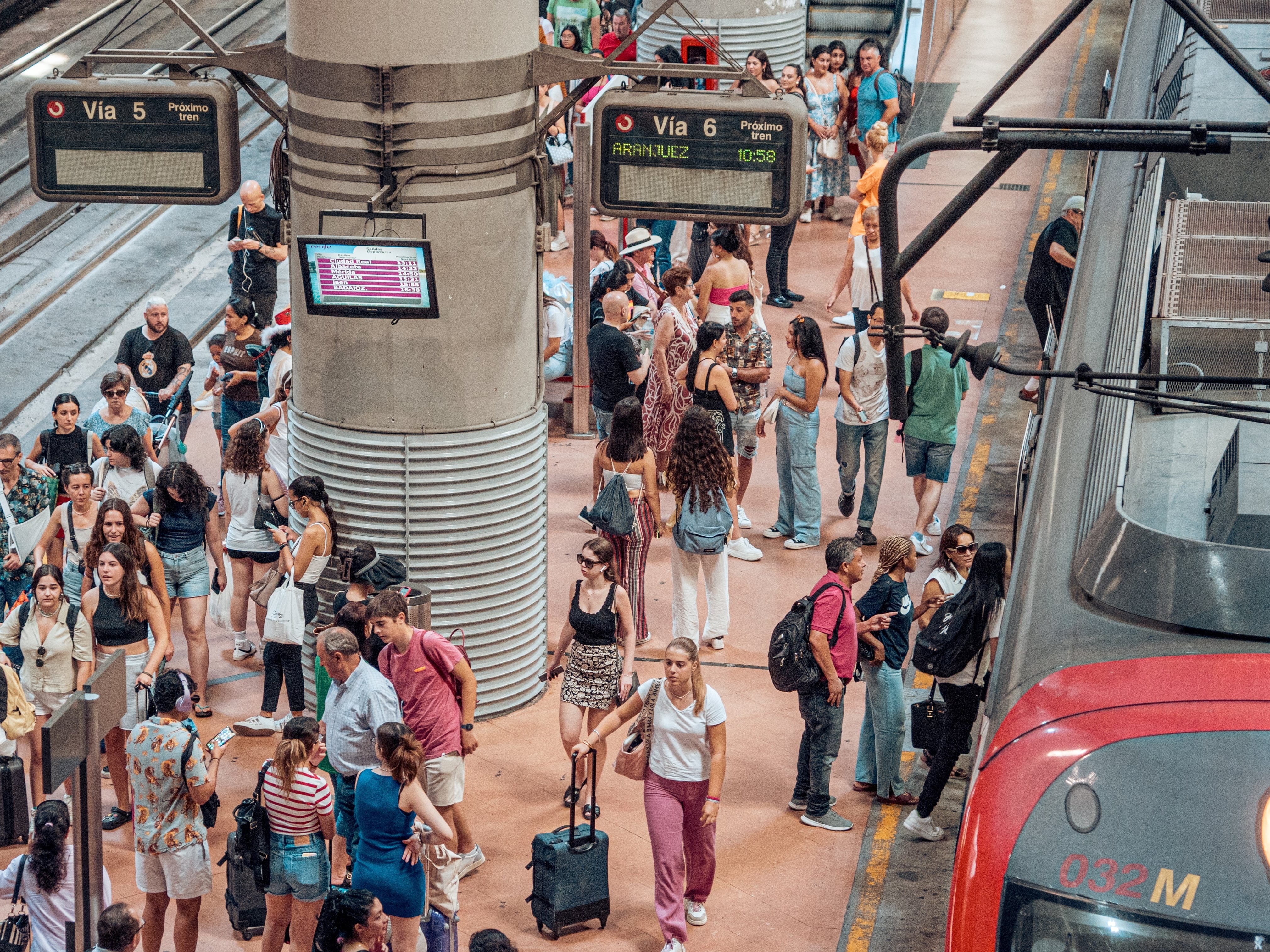 Viajeros junto a un tren de Cercanías en la estación madrileña de Atocha.