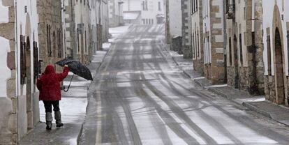 Un señor camina por la calle, durante el temporal de nieve que azota sobre todo al Norte de Navarra.