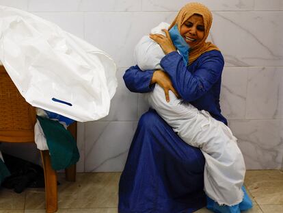 A woman hugs the body of a Palestinian child killed in Israeli attacks at a hospital in Khan Younis, in the southern Gaza Strip, on October 17.