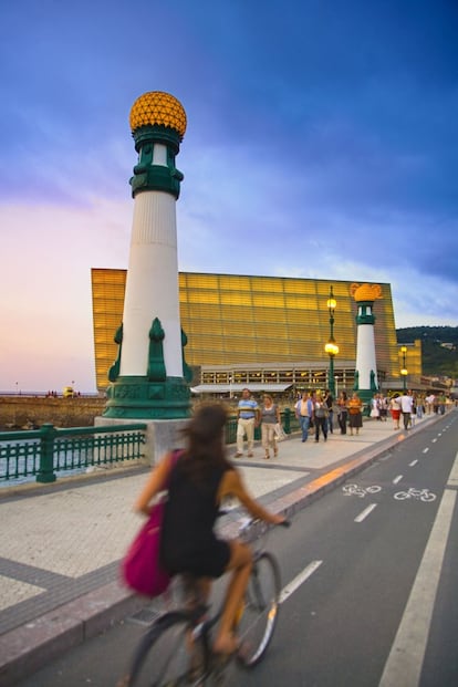 Una ciclista frente al Palacio de Congresos y auditorio del Kursaal de Rafael Moneo de San Sebastián (Guipúzcoa).
