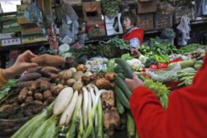 Una vendedora espera la llegada de clientes en un mercado de Pekín. EFE/Archivo