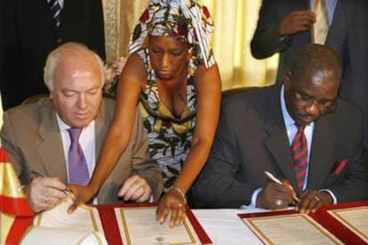 El ministro español de Asuntos Exteriores, Miguel Angel (izquierda), y su homólogo de Guinea-Conakry, Mamadi Conde (derecha), firman un acuerdo de cooperación en materia de inmigración.