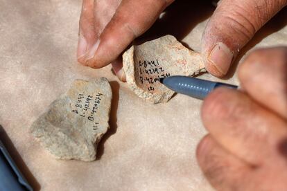 Un arqueólogo anota las piezas encontradas en el yacimiento para su posterior catalogación.
