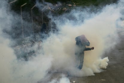 Un manifestante palestino trata de escapar de los gases lacrimógenos durante los choques con las tropas israelíes en Issawieyeh, Jerusalén Este.