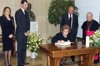 Los Reyes firman en el libro de condolencias de la Nunciatura.