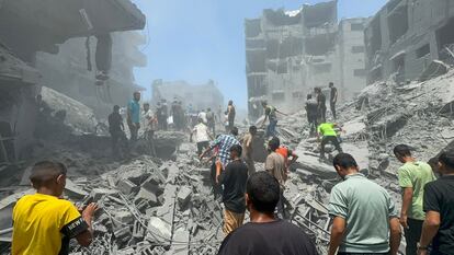 Un grupo de palestinos buscan víctimas entre los escombros tras un ataque israelí, este sábado en Ciudad de Gaza.