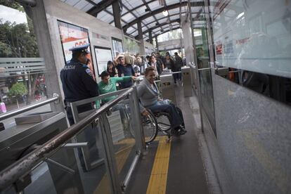 El agente de seguridad del Metrobús les deja pasar por una puerta especial. El acceso es gratuito para las personas con discapacidad.