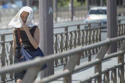 Una mujer se protege la cabeza con un pañuelo.