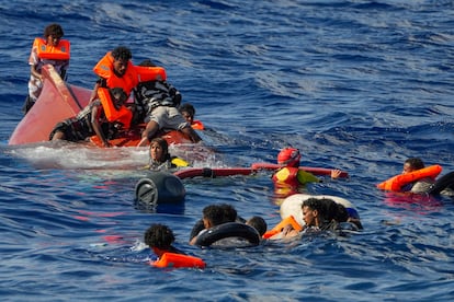 Socorristas de Open Arms ayudan a los migrantes después de que su bote de madera volcara.