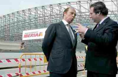 El presidente de Iberia, Antonio Vázquez, conversa con el alcalde de Barcelona, Jordi Hereu, durante el acto de izado de la cubierta del nuevo hangar de mantenimiento de Iberia en el Aeropuerto de El Prat.