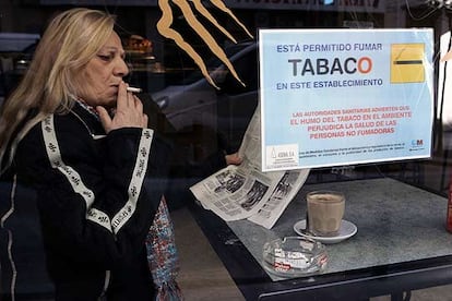 Una mujer fuma en un establecimiento en el que está permitido consumir cigarrillos.