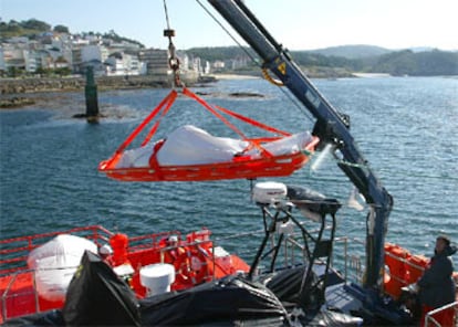 El pesquero gallego <i>O Bahía</i> se hundió en la noche del 2 de junio frente a las Islas Sisargas, en la Costa da Morte, con 10 marineros a bordo. En la imagen, una grúa lleva a tierra el cadáver de uno de los marineros.