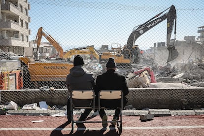 Dos hombres miran los trabajos de desescombro de un edificio en Nurdagi (Turquía), este lunes. 