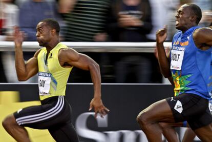 Gay y Bolt durante una carrera de 100 metros