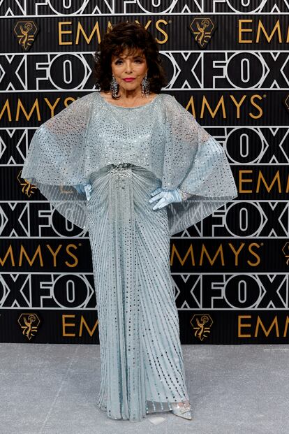 Joan Collins, maravillosa a los 90 años, con este vestido azul con pedrería de la diseñadora británica Jenny Packham.