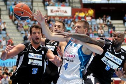 Los jugadores del Obradoiro Juvent y Ere luchan un rebote con el ala pívot del Lagun Aro GBC, Peter Lorant.