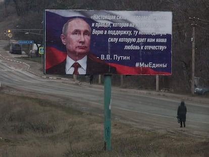 Una transeúnte, junto a un cartel que retrata a Putin, en Simferopol (Crimea).