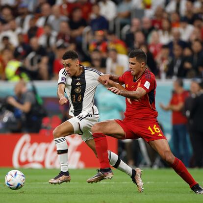 GR7500. AL KHOR (CATAR), 27/11/2022.- Rodri (d) de España disputa un balón con Jamal Musiala de Alemania hoy, en un partido de la fase de grupos del Mundial de Fútbol Qatar 2022 entre España y Alemania en el estadio Al Bait en Al Khor (Catar). EFE/ Alberto Estevez
