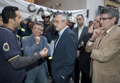 Griñán escucha ayer las quejas de un bombero en Cádiz, flanqueado por Francisco González (a la izquierda) y Luis Pizarro (derecha).