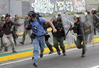 El fotoperiodista de Reuters, Marco Bello, corre mientras miembros de la  Guardia Nacional le persiguen, frente al Tribunal Supremo de Caracas. 