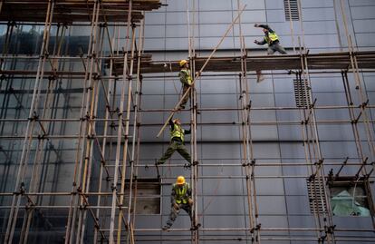 Obreros trabajan subidos en andamios en una construcción en Beijing. 