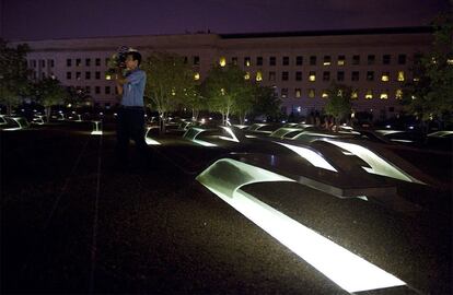 Un vigilante porta un ramo de flores por el memorial en homenaje a las 184 personas que perdieron la vida cuando uno de los aviones secuestrados por terroristas se estrelló contra el edificio del Pentágono en Washington, antes del comienzo de la ceremonia del décimo aniversario de los atentados del 11S en el Pentágono en Arlington, Virginia (Estados Unidos)