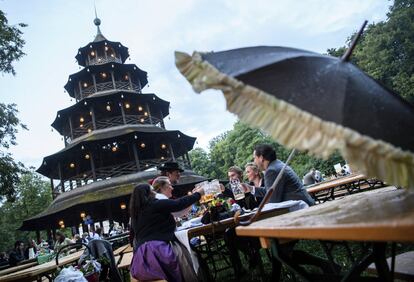 Varias personas beben unas cervezas durante el tradicional 'Kocherlball' en los Jardines Ingleses en Múnich, Alemania.