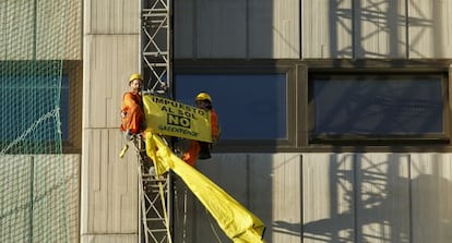 Dos activistas de Greenpeace protestan ante la sede del ministerio de Industria en Madrid.