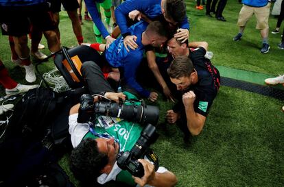 El goleador croata Mario Mandzukic tira al suelo al fotógrafo salvadoreño Yuri Cortez, tras la celebración del segundo gol de Croacia en la semifinal ante Inglaterra, el 11 de julio de 2018.