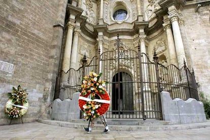 La catedral de Valencia fue el lugar escogido para el funeral institucional por los 41 muertos en el accidente del metro de Valencia. Un centenar de personas, entre ellas religiosas, voluntarios del Encuentro Mundial de las Familias y ancianos, esperaban a la entrada de la catedral desde dos horas antes del comienzo de la misa. En la imagen, un hombre deposita una corona de flores en la puerta del templo.