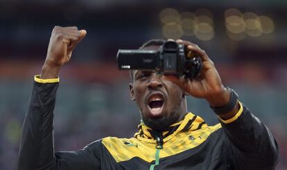 Bolt graba un vídeo durante la ceremonia de medallas de la final de los 100m