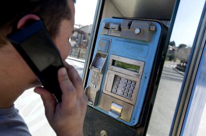 Un joven utiliza una cabina de tel&eacute;fono en Madrid.