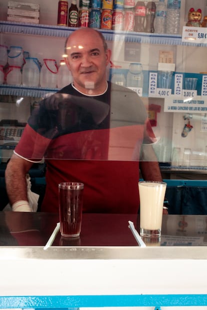 José sirviendo agua de cebada y horchata en el kiosco.