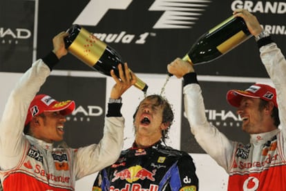 Lewis Hamilton y Jenson Button, de McLaren Mercedes, remojan al vencedor de la carrera y del Mundial, Sebastian Vettel, en el podio.