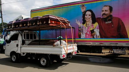 Um caminhão com caixões passa diante de um cartaz do casal presidencial em Masaya, Nicarágua, em 2 de novembro.