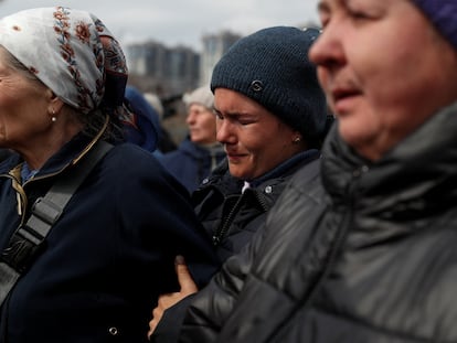 Tres mujeres trataban el viernes de reconocer a sus familiares entre los cadáveres de civiles hallados en la localidad de Bucha, al noroeste de Kiev.