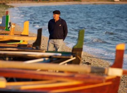 Uxío Allo observa una dorna en la playa de Bao, en la Illa de Arousa.