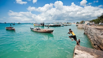 Unos adolescentes saltan al océano turquesa en Stone Town, Zanzíbar.