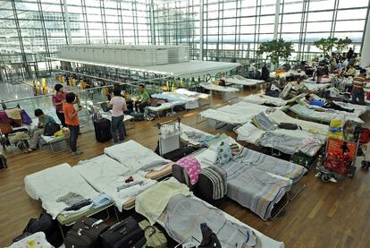 Cientos de pasajeros descansan en camas mientras esperan la salida de sus vuelos en el aeropuerto de Mnich.