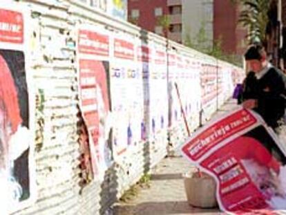Un hombre pega carteles de cotillones de Nochevieja en Almería.