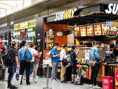 Ciudadanos chinos hacen cola en un restaurante de comida rápida en una estación de tren de Sanghái.