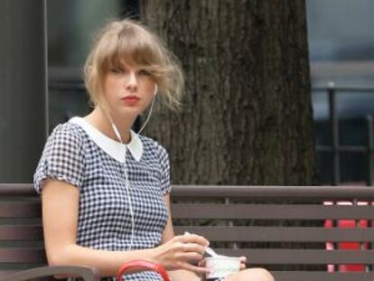 Taylor Swift, tomando um iogurte em um parque de Nova York.