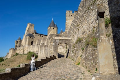 Una mujer está en la puerta del Aude, en la villa fortificada de Carcasona, región de Languedoc-Rosellón, Francia. 