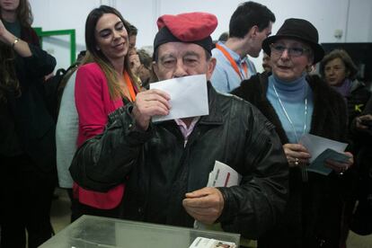 Un hombre con una barretina besa su voto antes de introducirlo en la urna en Barcelona.