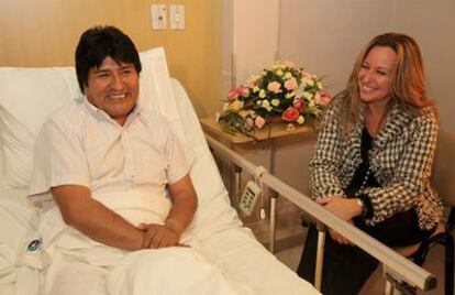 La ministra de Asuntos Exteriores conversa con el presidente de Bolivia, Evo Morales, en la clínica donde el mandatario fue operado de la rodilla izquierda por una tendinitis rotuliana.