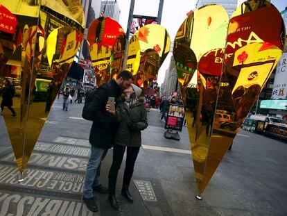 Una pareja se besa entre corazones en Nueva York.