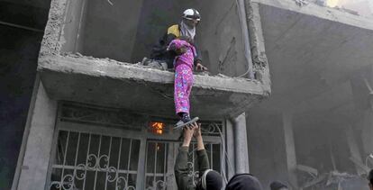 Un miembro de la Defensa Civil Siria rescata a una niña en Guta Oriental.