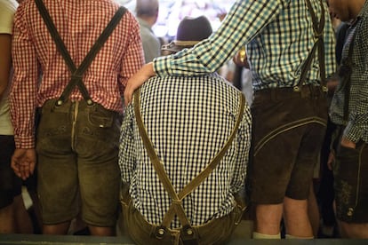 Varios asistentes vestidos con trajes tradicionales participan en la 184 edición del festival Oktoberfest celebrado en Múnich.